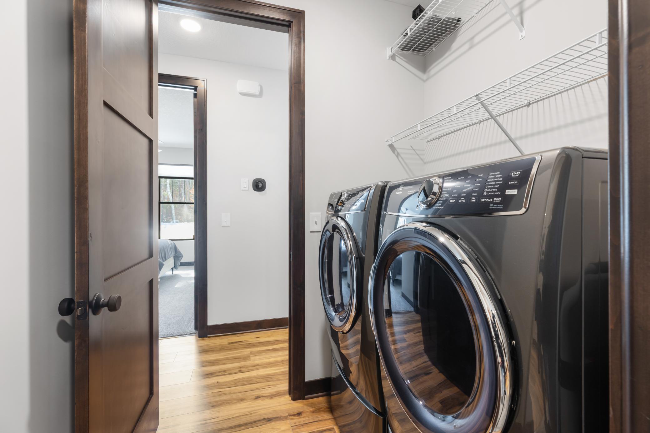 Main-level laundry is thoughtfully positioned between the primary closet and the hallway to the additional bedrooms for easy, everyday access.