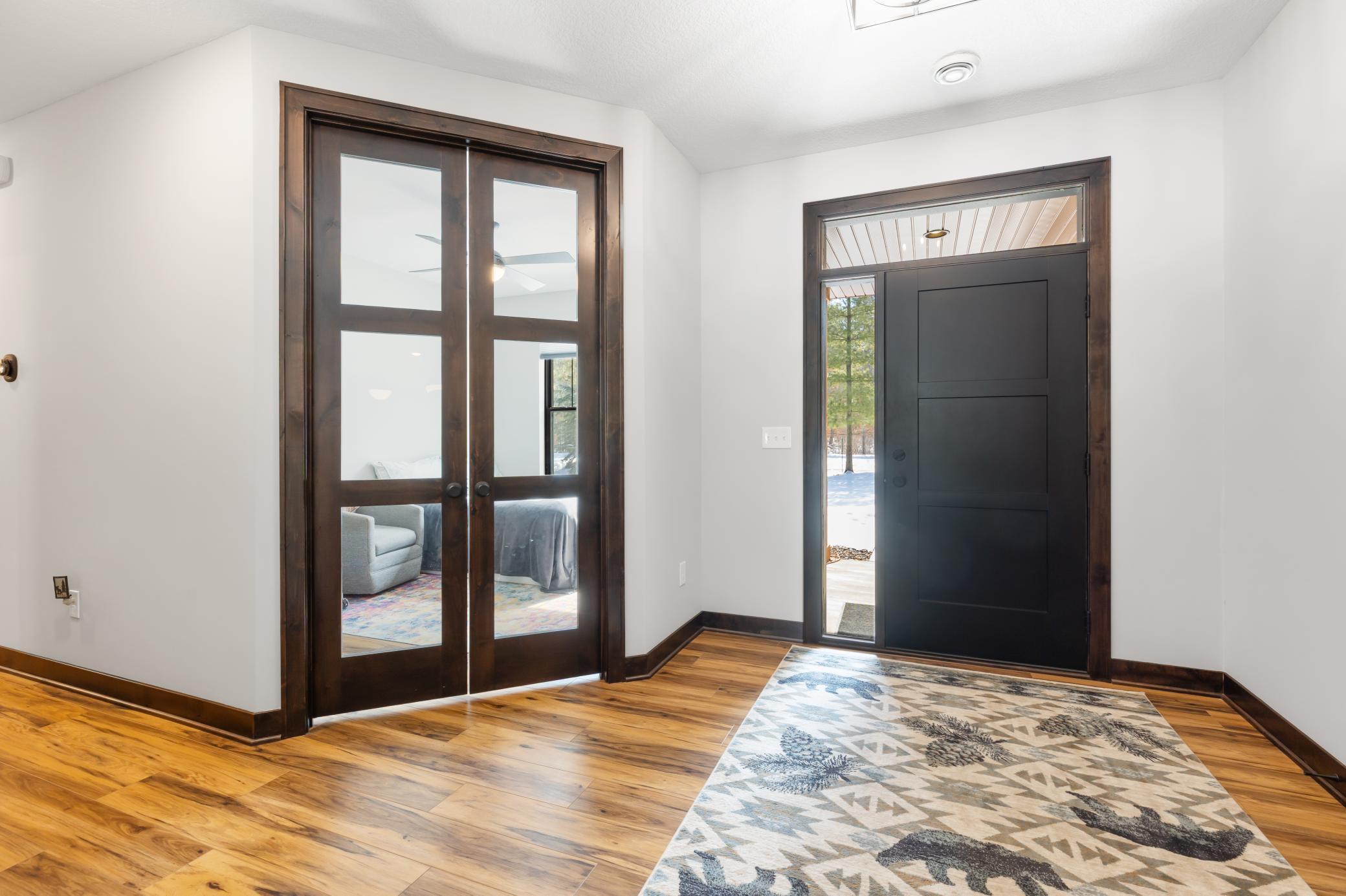 A bright and spacious foyer welcomes you, creating a stunning first impression as you enter this elevated home. To the left, you can see the beautiful custom doors that lead to the third bedroom.