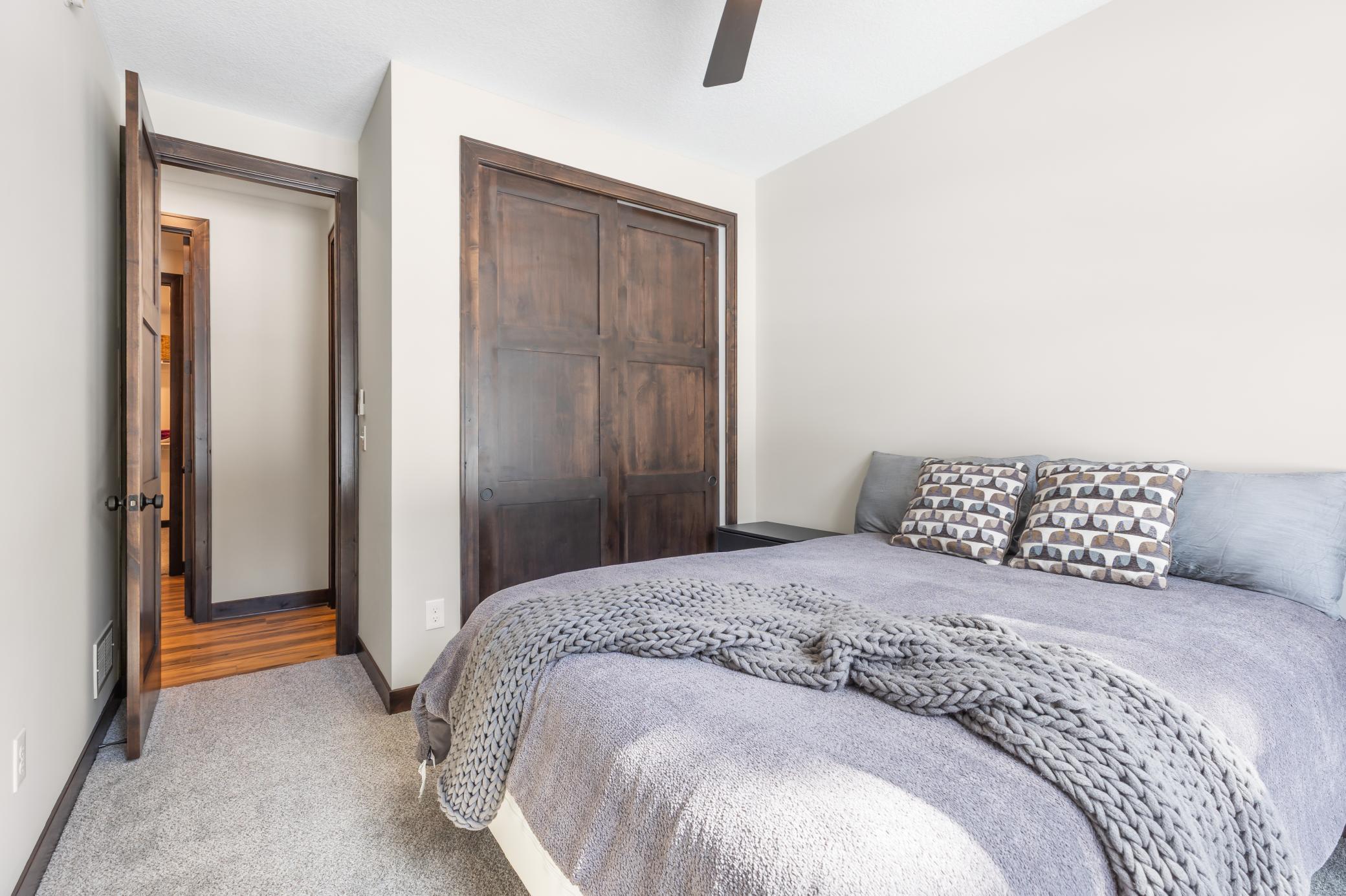 A bright and airy second bedroom with expansive 8-foot closet doors, tucked at the end of the hall.