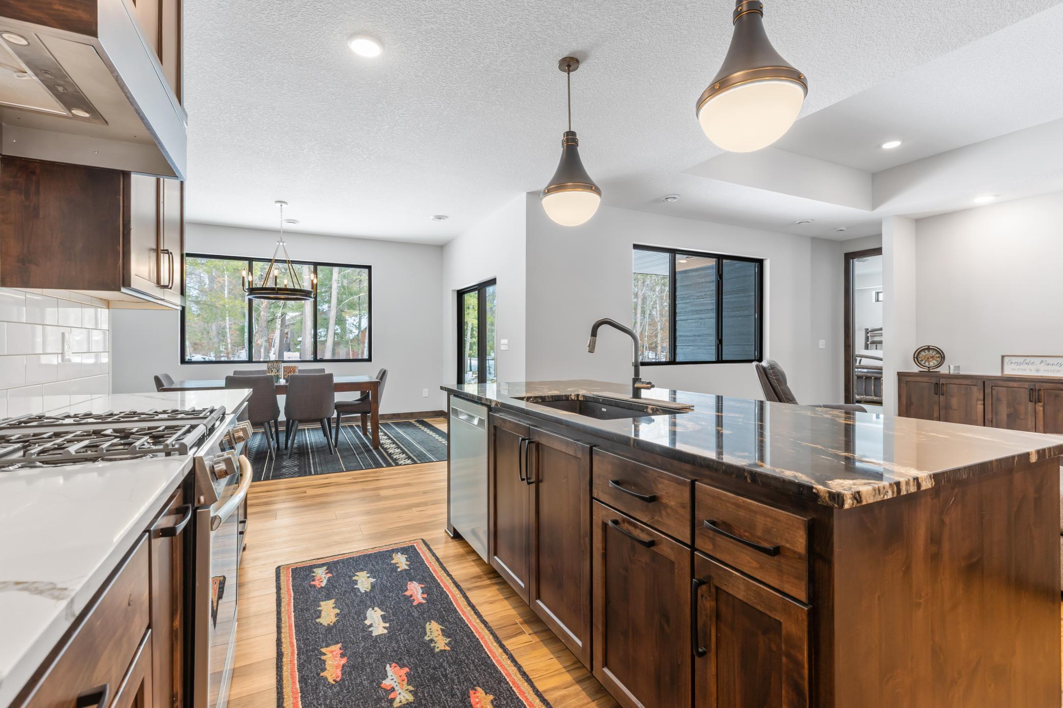 Flush-mount, minimalist windows drench the space in warm light, tying the kitchen beautifully to the dining and living spaces.
