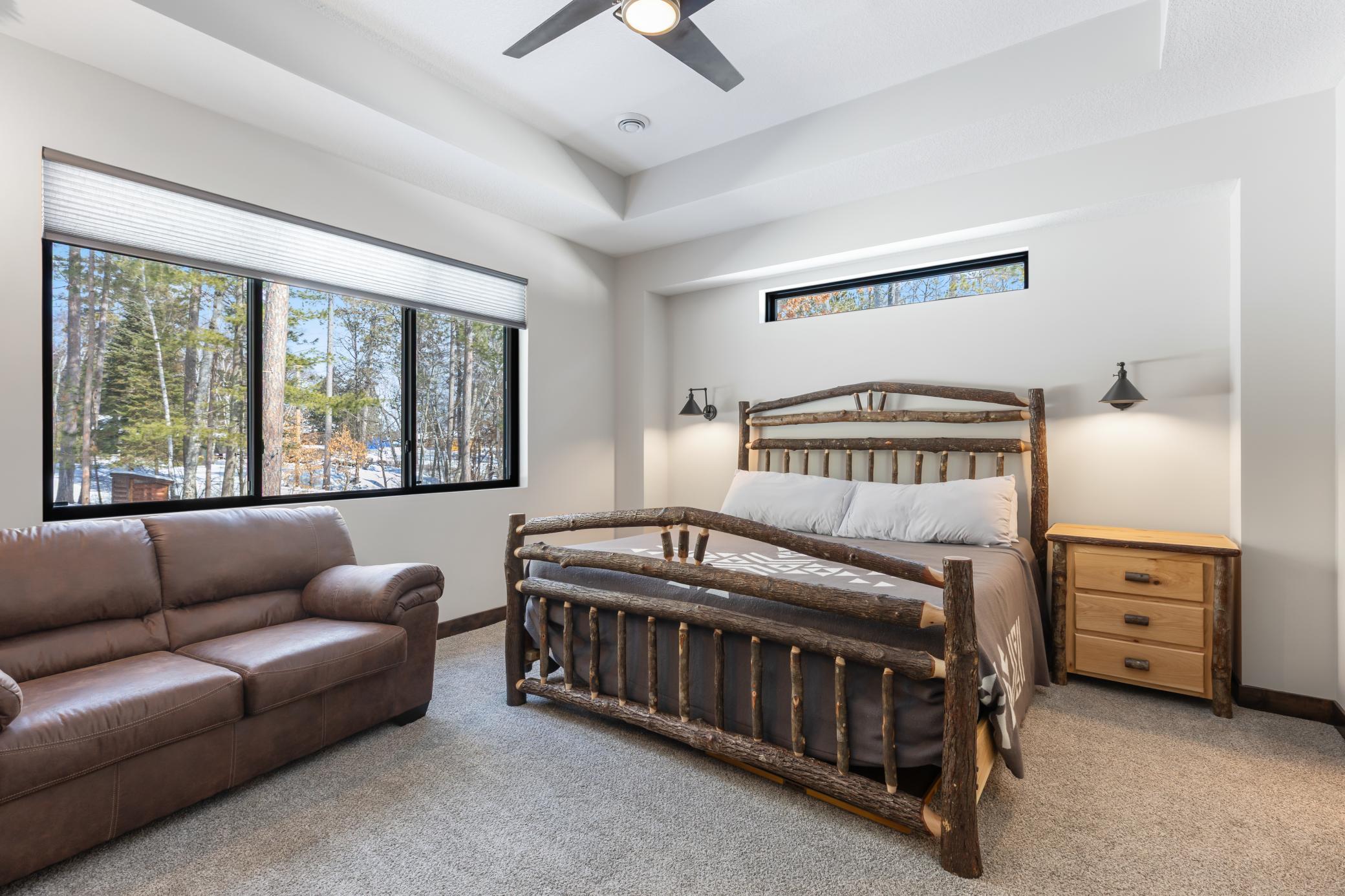 The spacious primary suite features stunning views of the private, wooded lot and has room for a king bed plus additional seating.