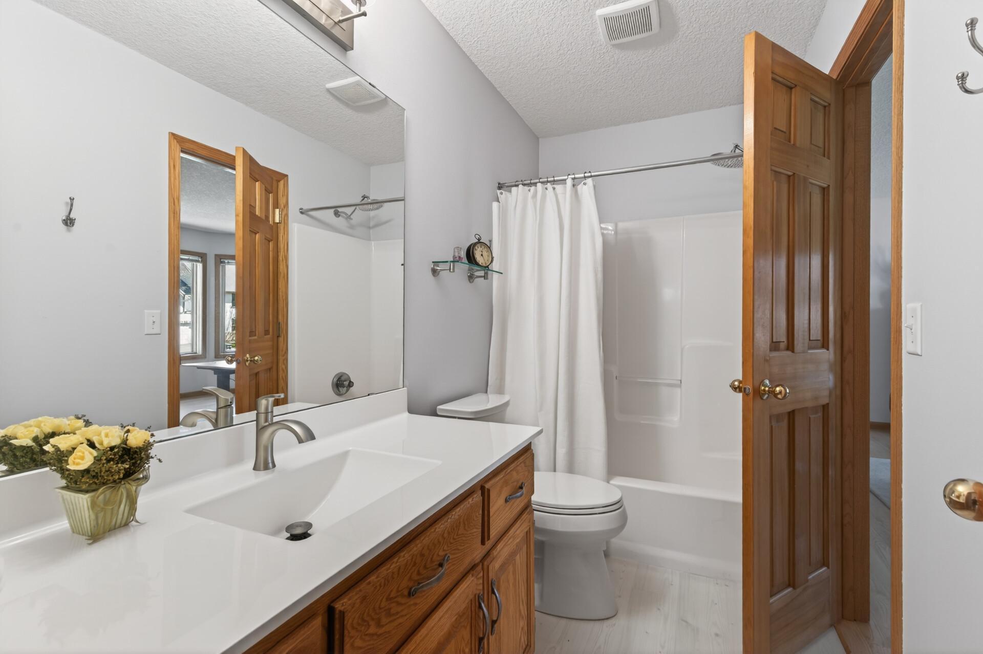 Main level hall bath with brand new floor has access to the 2nd bedroom/office