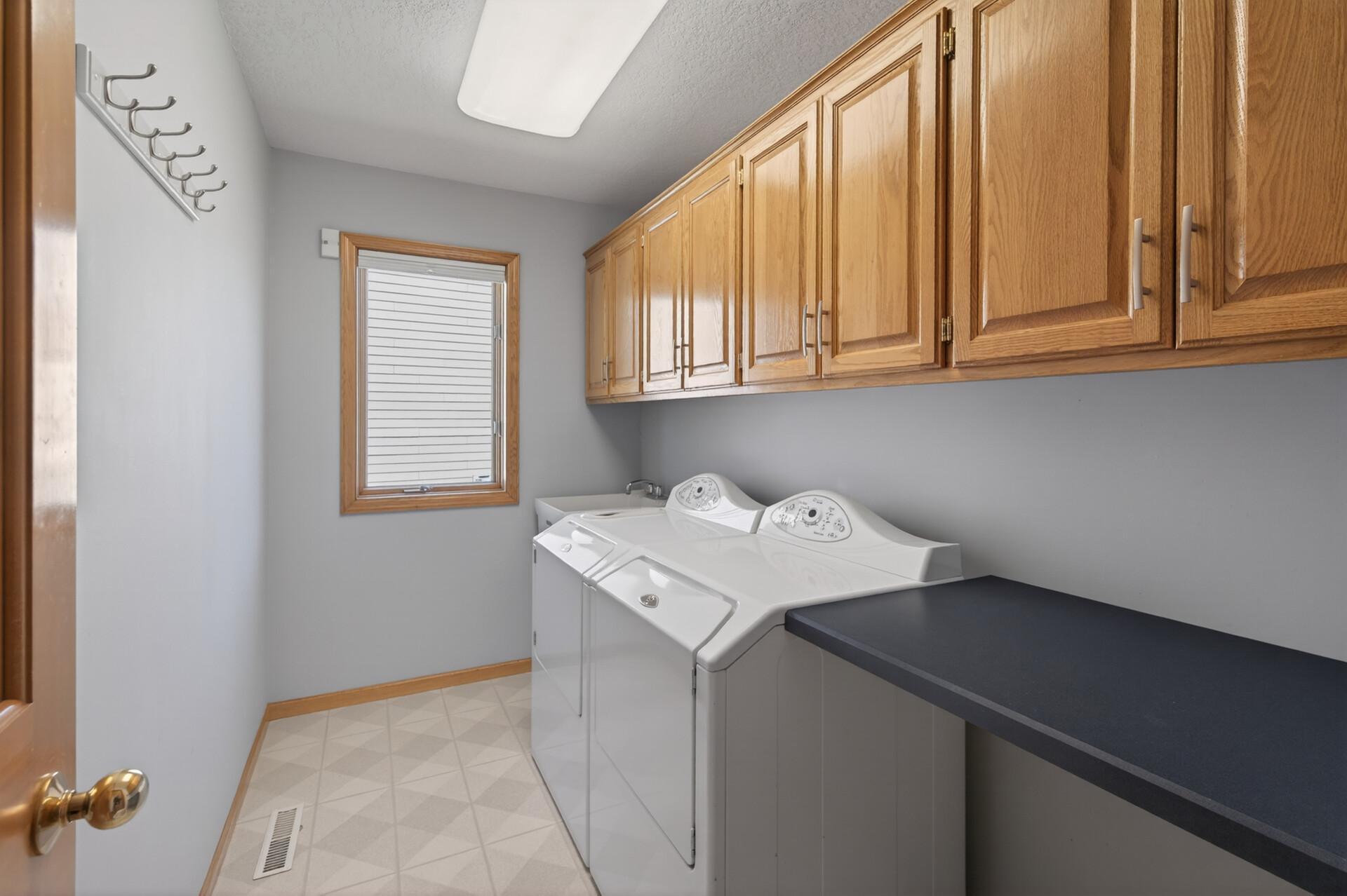 Main floor laundry room with lots of storage & a convenient countertop