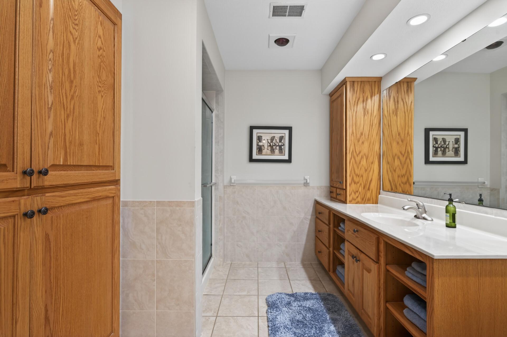 Lower level 3/4 tile bath with a linen closet, linen tower & large vanity