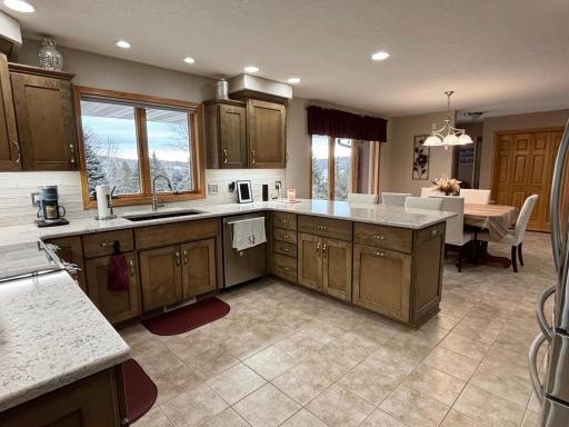 Remodeled kitchen with stone countertops, refinished custom cabinetry, and updated appliances.