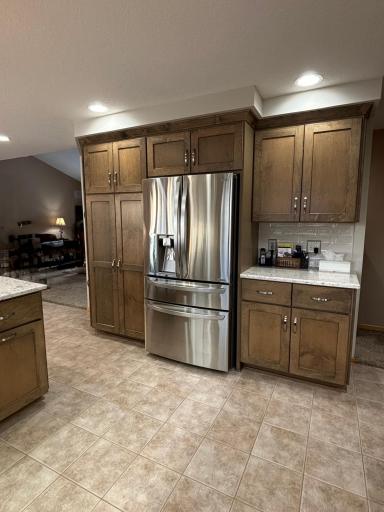 Remodeled kitchen with stone countertops, refinished custom cabinetry, and updated appliances.