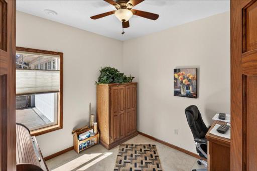 Versatile and sun-filled bedroom perfect for a home office, reading nook, or guest space, featuring a large window for natural light and a ceiling fan for added comfort.