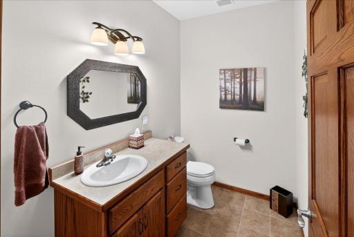 Convenient main-level half bath with updated lighting, large vanity, and plenty of storage.