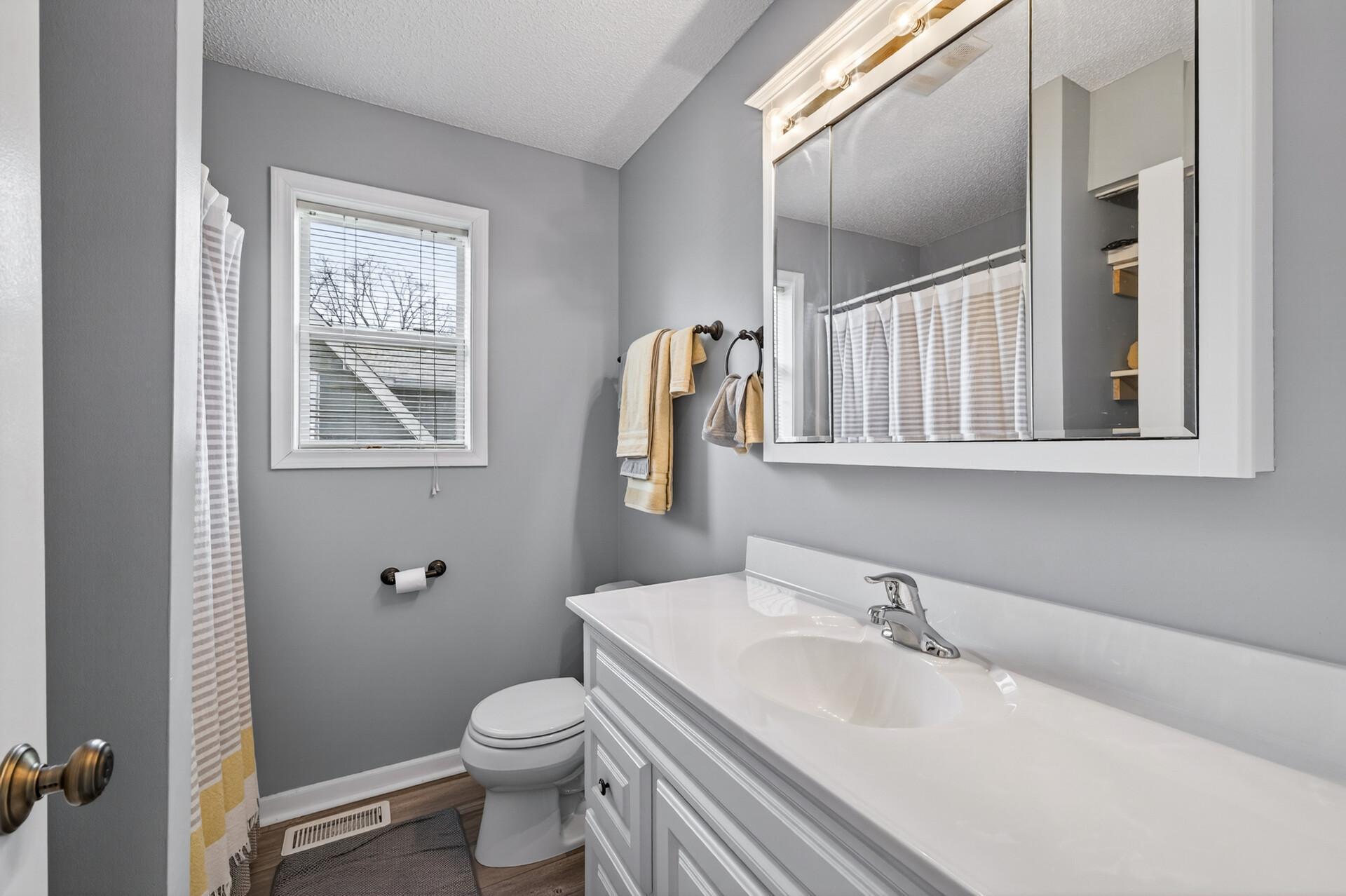 Updated primary 3/4 bathroom featuring a large vanity, modern fixtures, and natural light from the window.