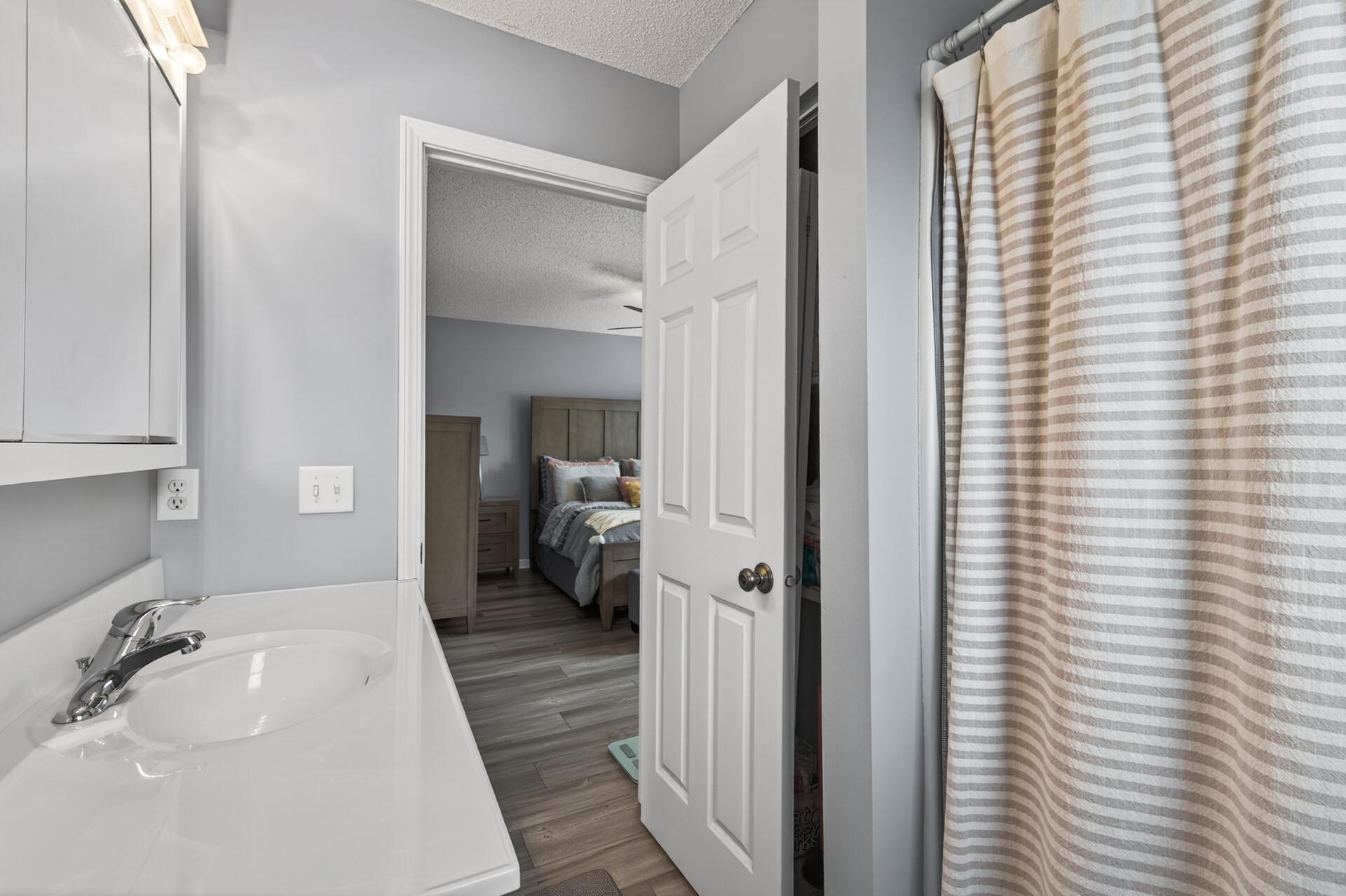 Additional bathroom angle showcasing clean finishes, brand new luxury vinyl plank (LVP) flooring, and bright natural lighting.