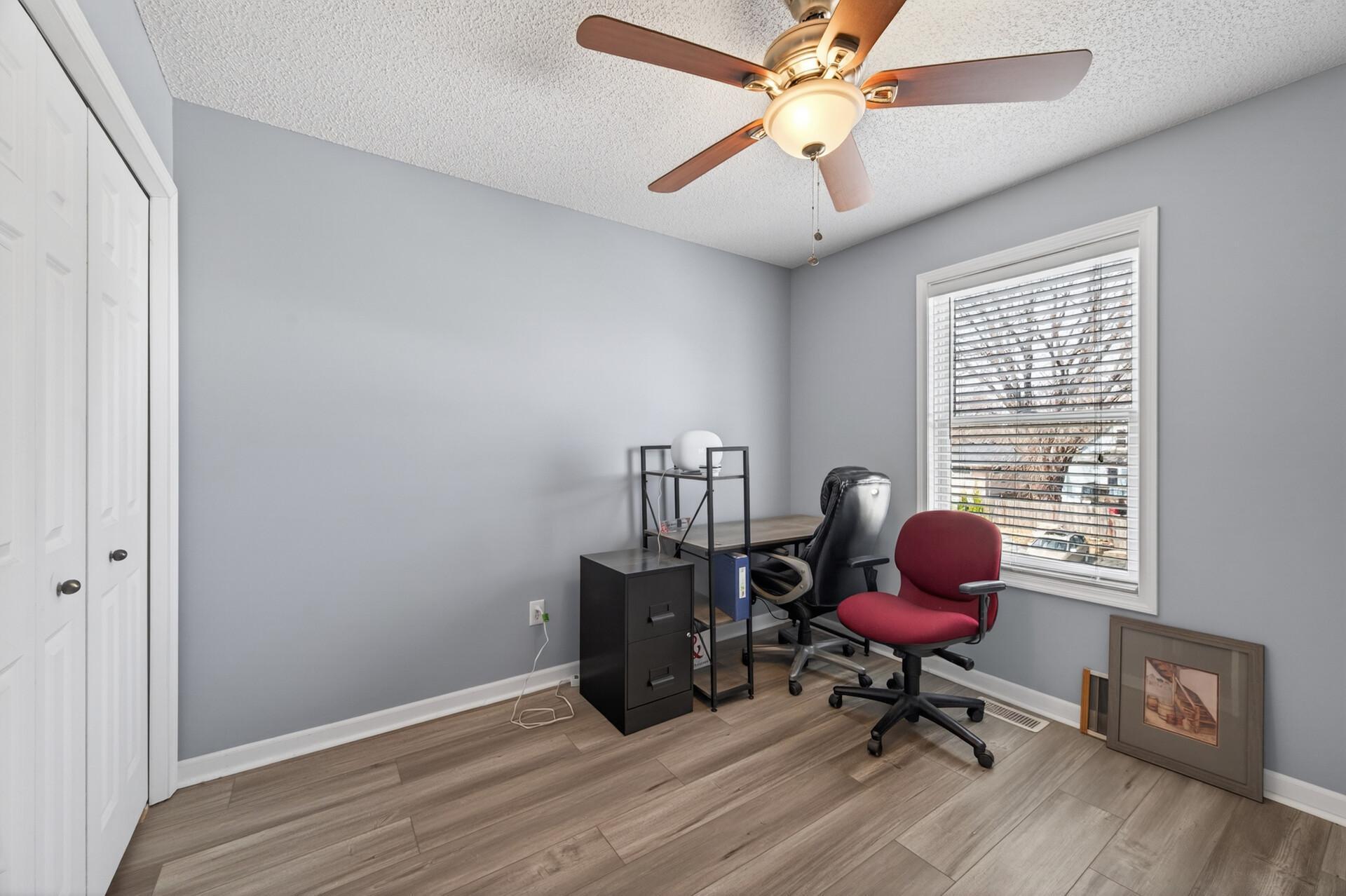 Third bedroom or office space featuring brand new luxury vinyl plank (LVP) flooring, ceiling fan, and fresh paint; offering flexible layout options.