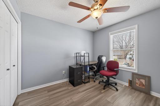 Third bedroom or office space featuring brand new luxury vinyl plank (LVP) flooring, ceiling fan, and fresh paint; offering flexible layout options.