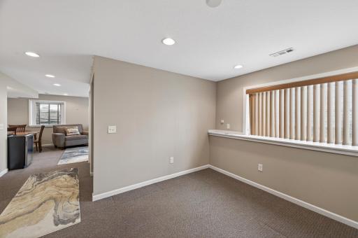 Spacious lower-level living area featuring plush carpeting and recessed LED lighting, offering flexible space for a family room, recreation area, or potential 4th bedroom with the addition of a wall and door.