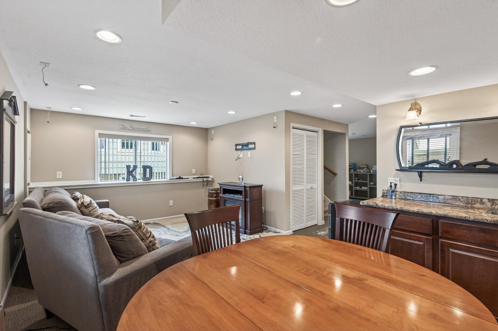 Open lower-level layout showing seating, bar area, and easy flow for hosting and relaxation.