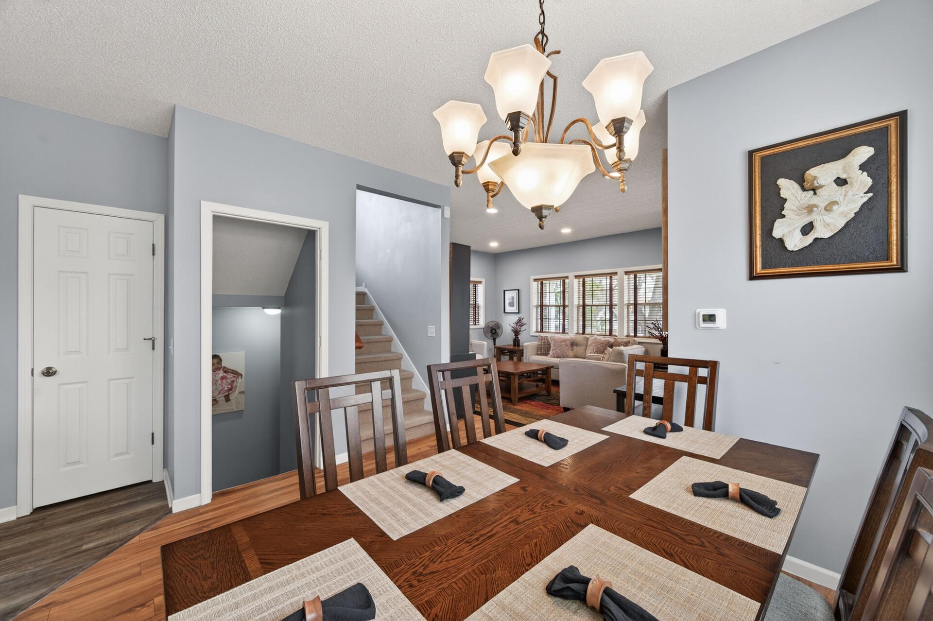 Spacious dining room featuring a stylish chandelier and seamless flow into both the kitchen and living areas; an ideal setup for hosting family and friends
