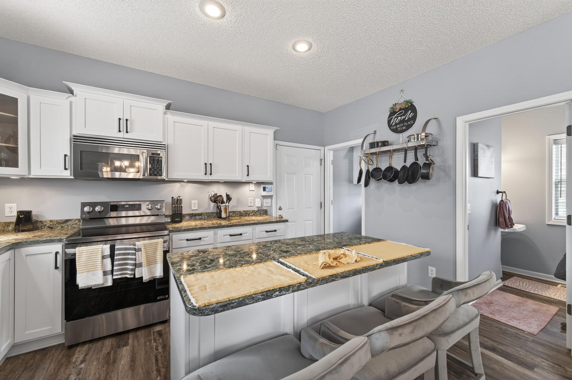 Additional kitchen view showcasing breakfast bar seating and open flow to adjacent spaces. A perfect blend of style and functionality for daily living.