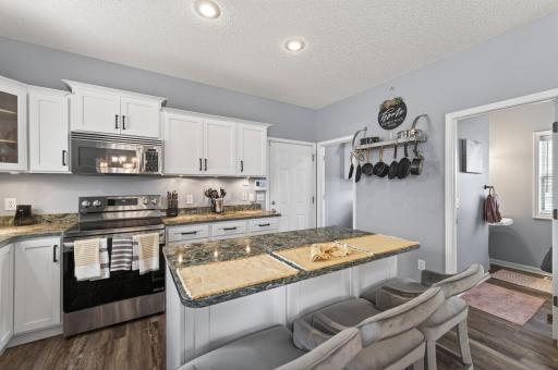 Additional kitchen view showcasing breakfast bar seating and open flow to adjacent spaces. A perfect blend of style and functionality for daily living.