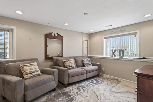 Lower-level living area with cozy seating, recessed lighting, and neutral finishes—perfect for relaxing or entertaining.