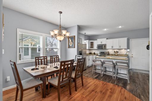 Generous dining area with large windows and an elegant light fixture, creating a bright and inviting space for meals and gatherings. Conveniently located just off the kitchen.