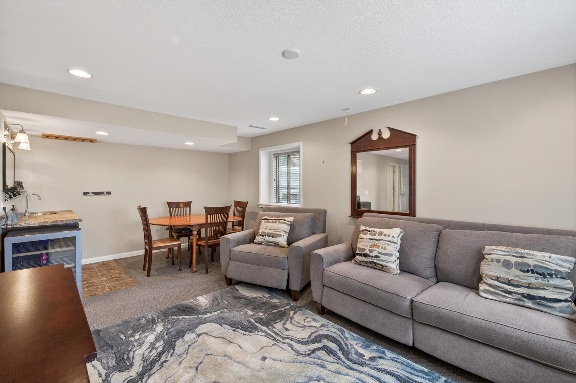 Basement entertaining space with wet bar, dining area, and flexible gathering space.