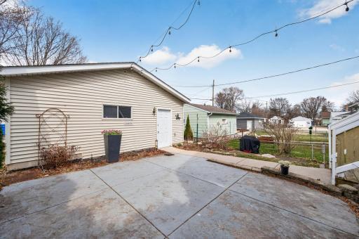 Detached garage with convenient access from the patio, complemented by low-maintenance landscaping and outdoor lighting.