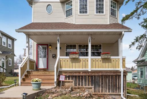 Charming two-story home with inviting curb appeal, featuring a welcoming front porch and mature trees. The elevated lot offers added privacy, complemented by a well-maintained walkway leading to the entrance.