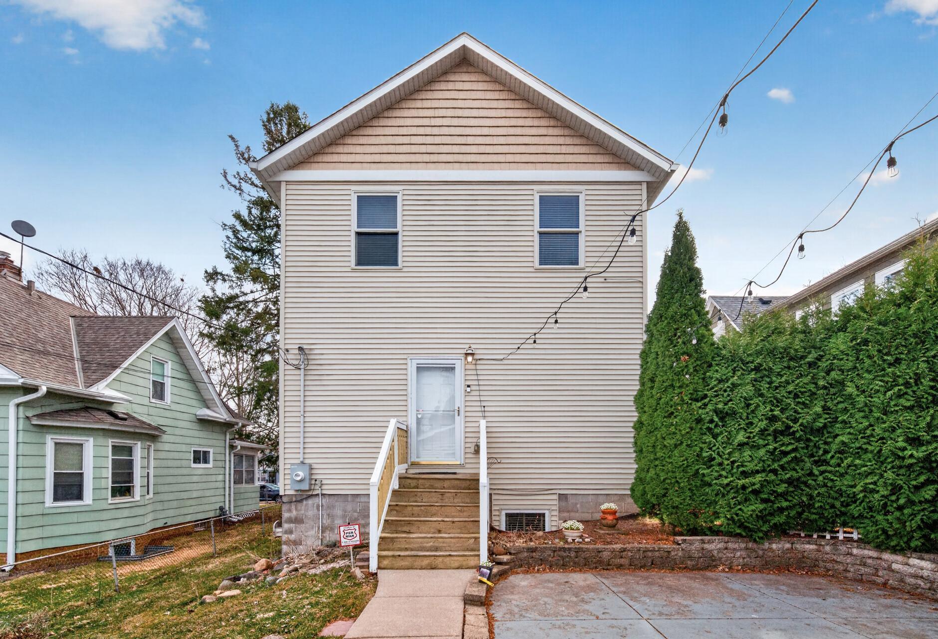 Rear exterior showcasing the home’s two-story design, back entry access, and well-maintained siding.