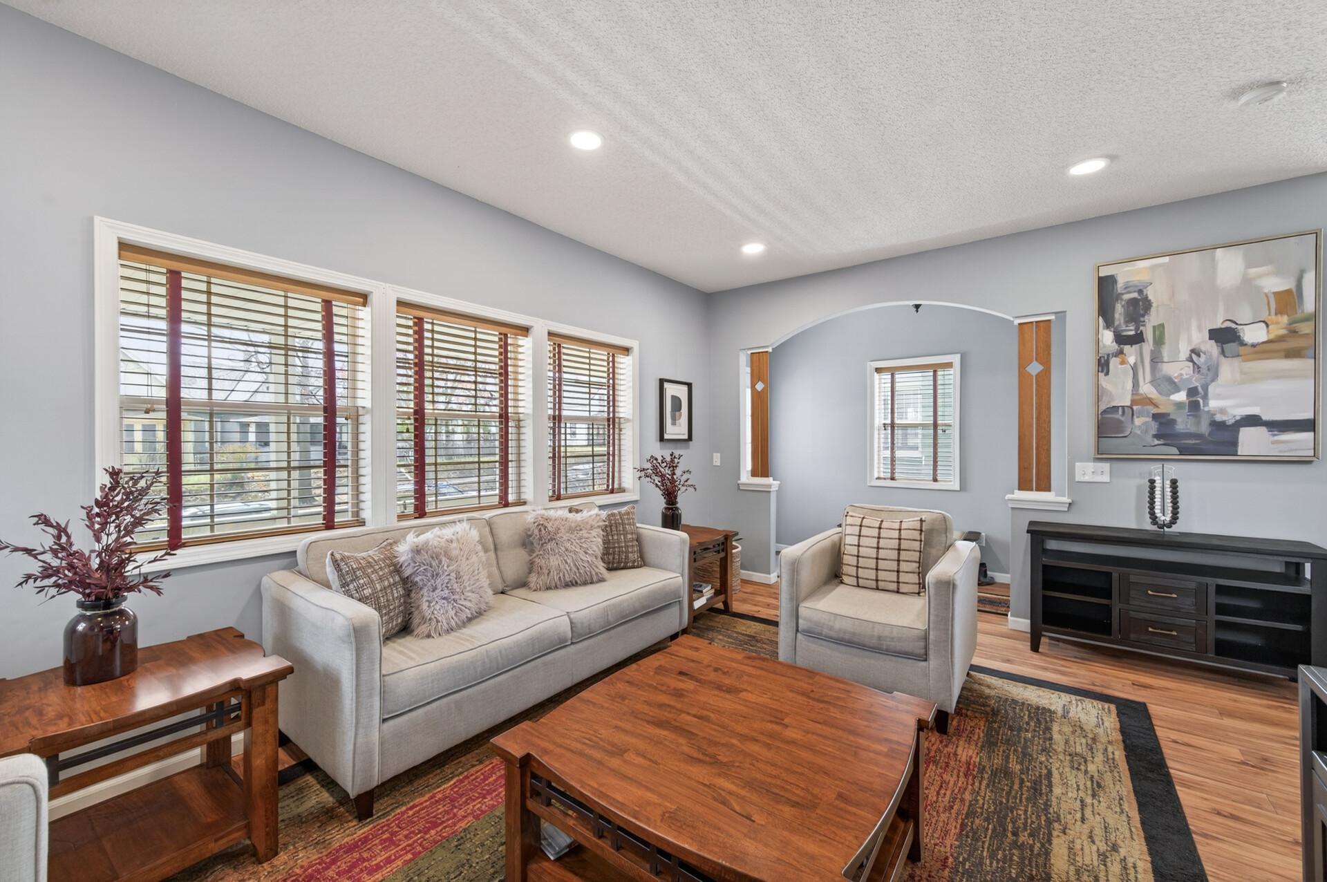 Light-filled living room featuring brand new LED lighting and large windows that invite abundant natural light, offering a comfortable balance of openness and warmth.