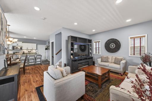 Spacious main-level living area featuring an open-concept layout, recessed LED lighting, and beautiful natural wood floors throughout, perfect for everyday living and entertaining.