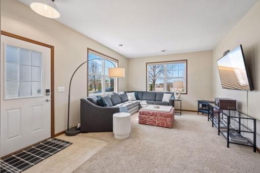Spacious living room with large windows. Windows face south and west, providing wonderful sunlight. Great in the winter! There are blinds on all the windows. Please exclude electric fireplace.