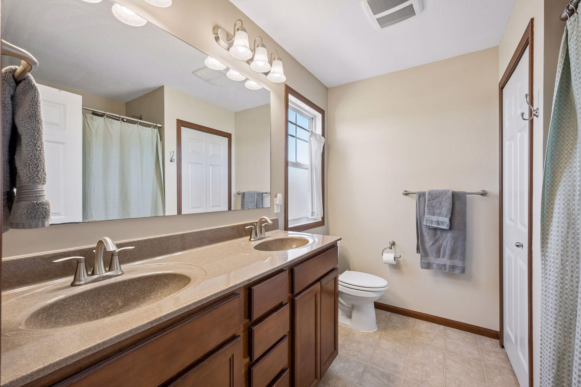 Primary full bath with dual sinks, linen closet and a window that opens!