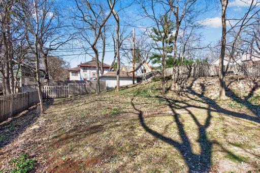 The oversized yard features garden space and mature trees