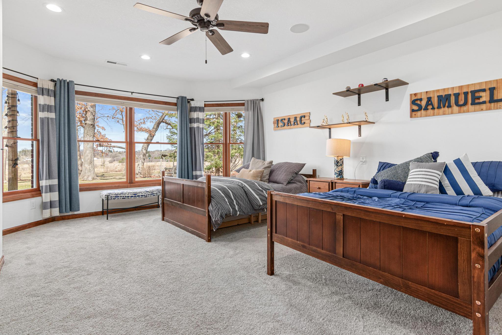 This spacious lower-level bedroom offers flexibility for guests or family. Walls of windows allow the outdoors in and provide beautiful views!