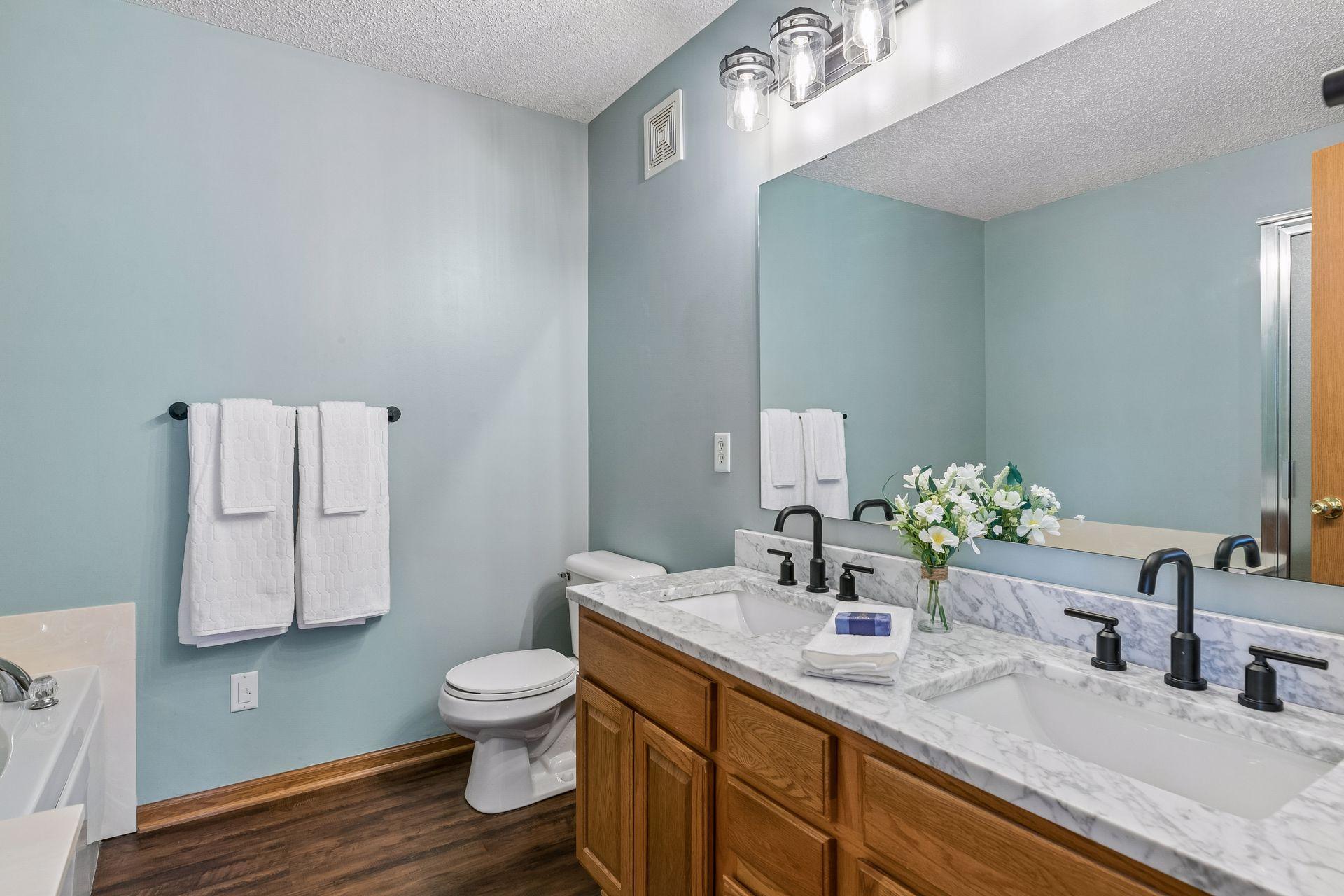 Private primary bath featuring upgraded dual sink vanity top