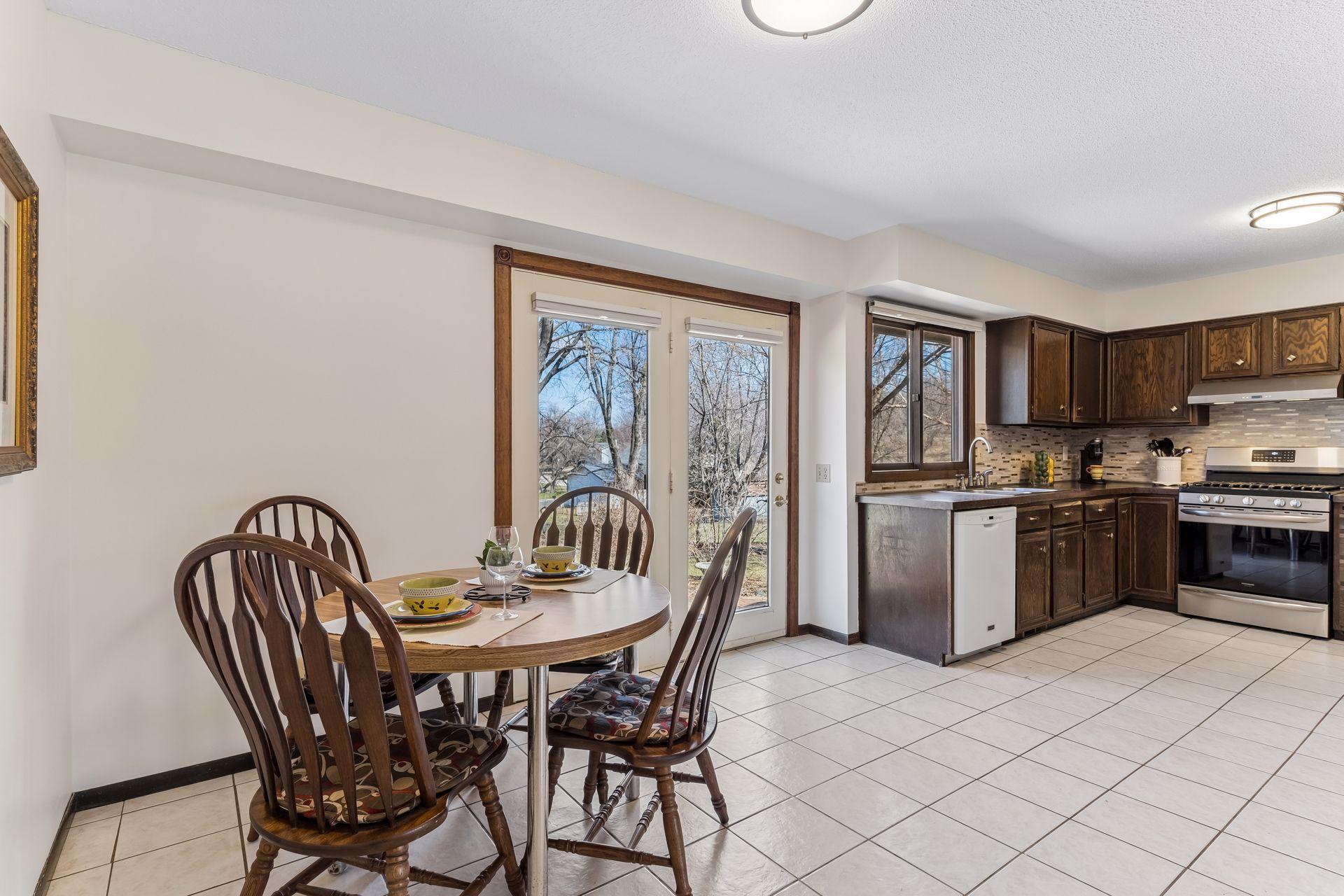 Open kitchen and dining space featuring ample cabinetry, tile flooring and natural light, ideal for cooking and hosting.