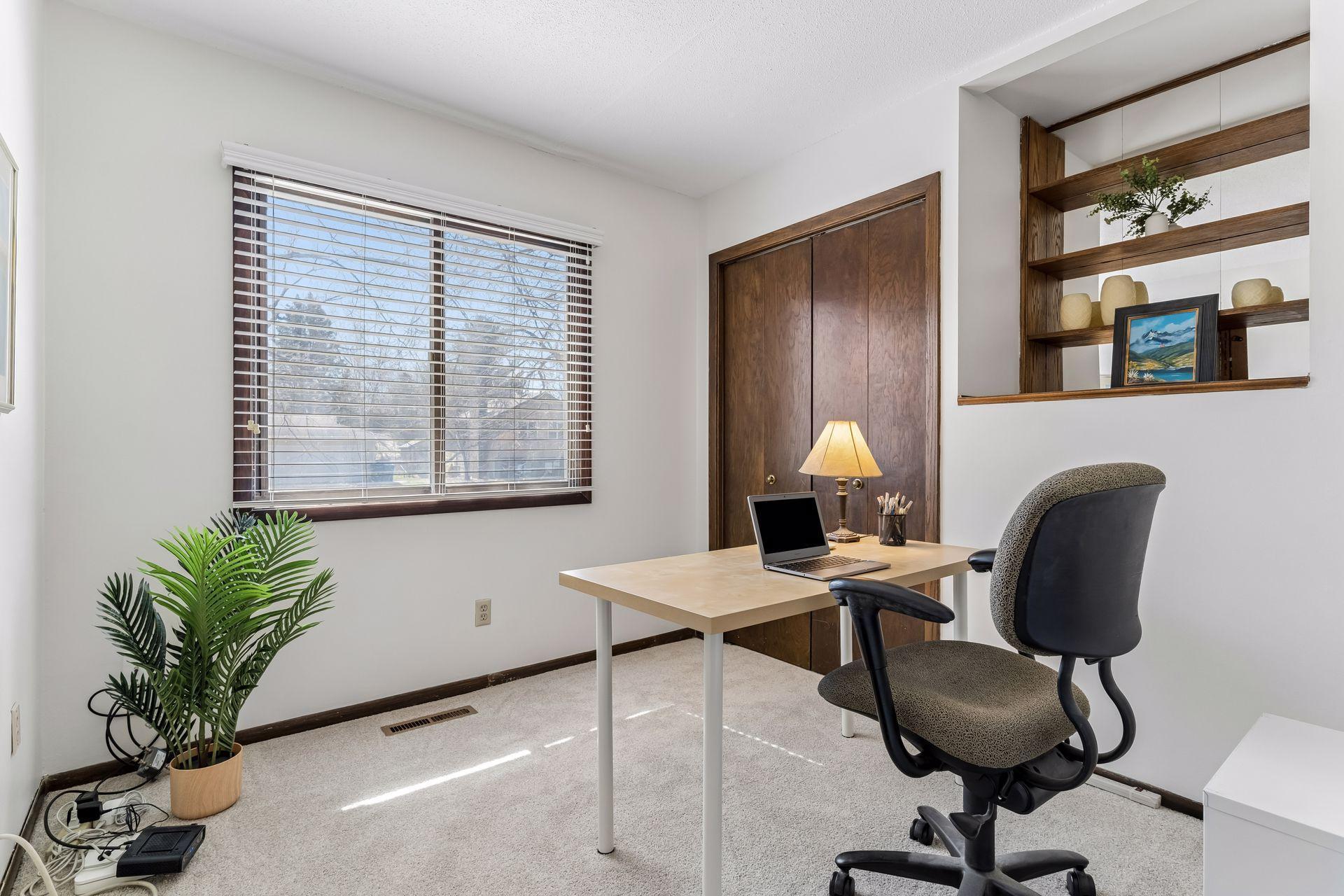 Third bedroom on upper level, ideal for guest room, home office, or flex space, featuring new carpeting and natural light.