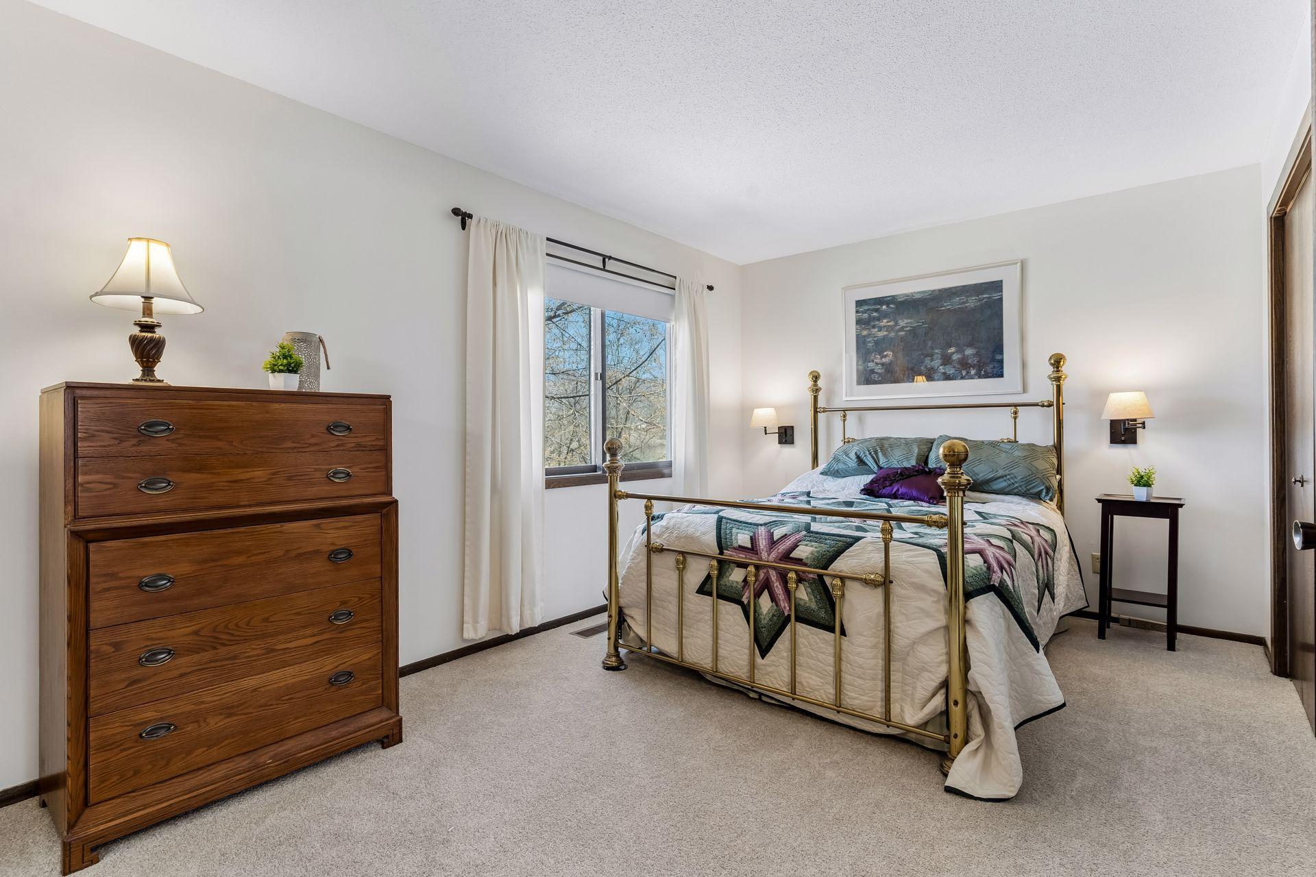 Upper level primary bedroom featuring new carpeting, spacious layout, large window and natural light.
