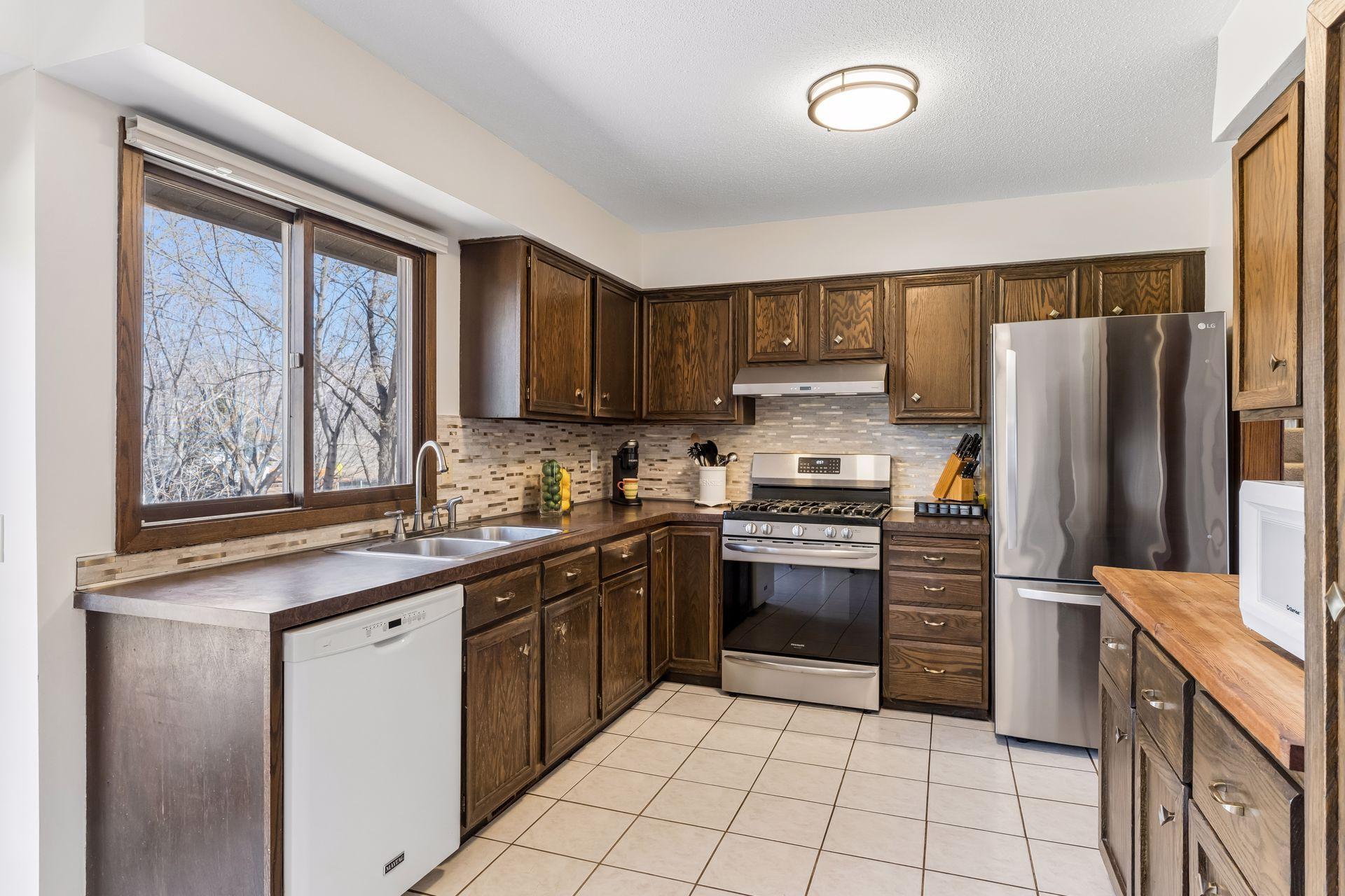 Kitchen with stainless steel appliances, generous counter space, tile backsplash, and functional layout for everyday convenience.