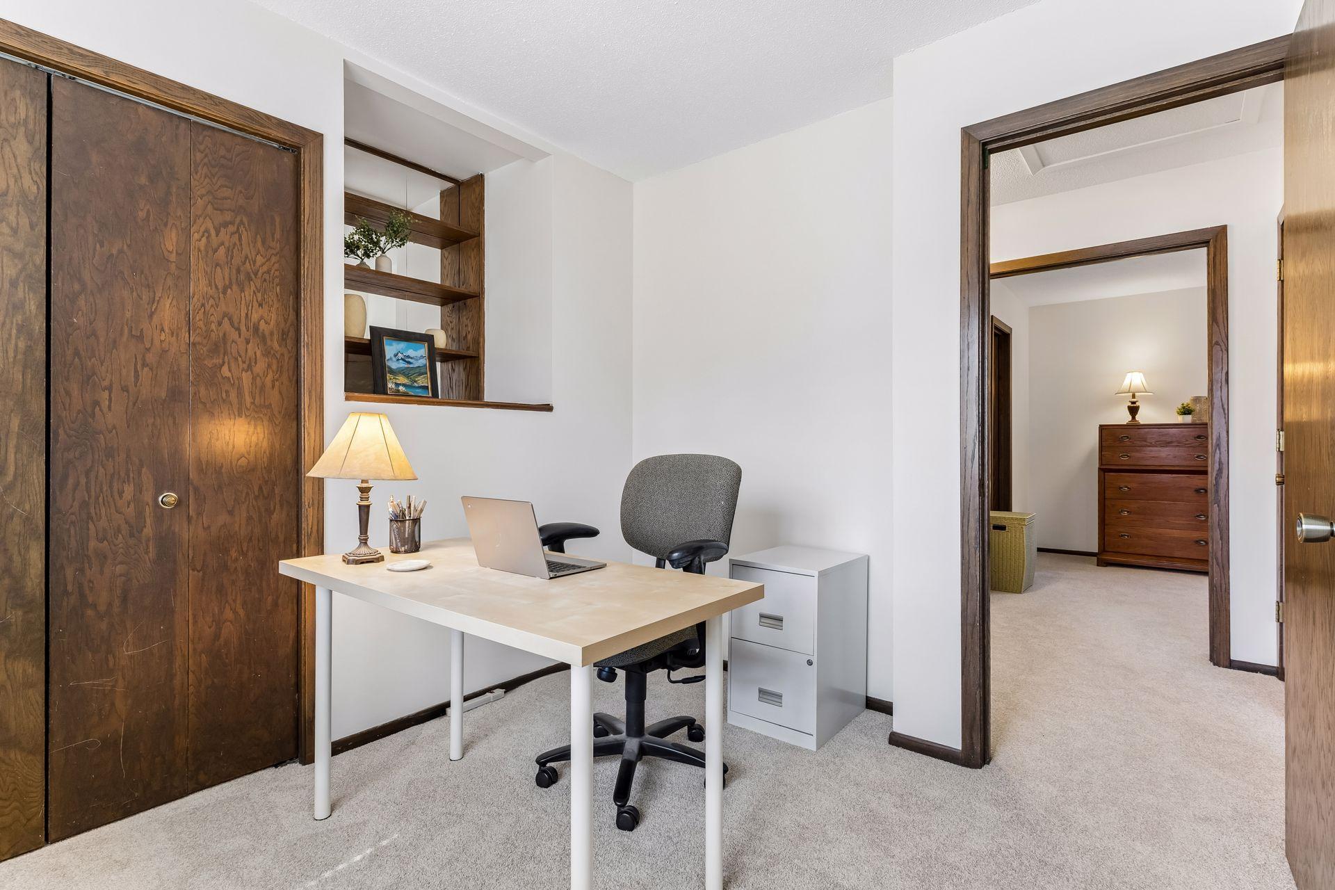 Additional view of third bedroom showcasing built-in shelving detail, workspace potential and closet access.