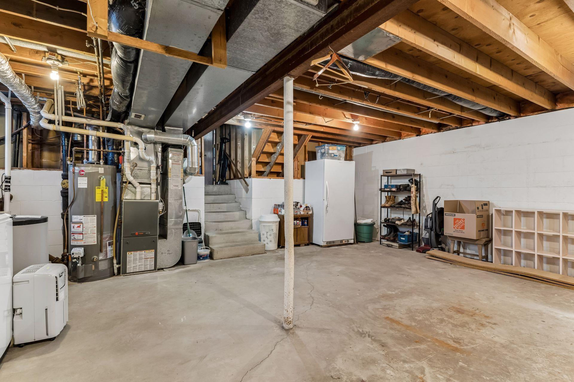 Additional basement view showcasing mechanicals, workspace, and large open storage area.