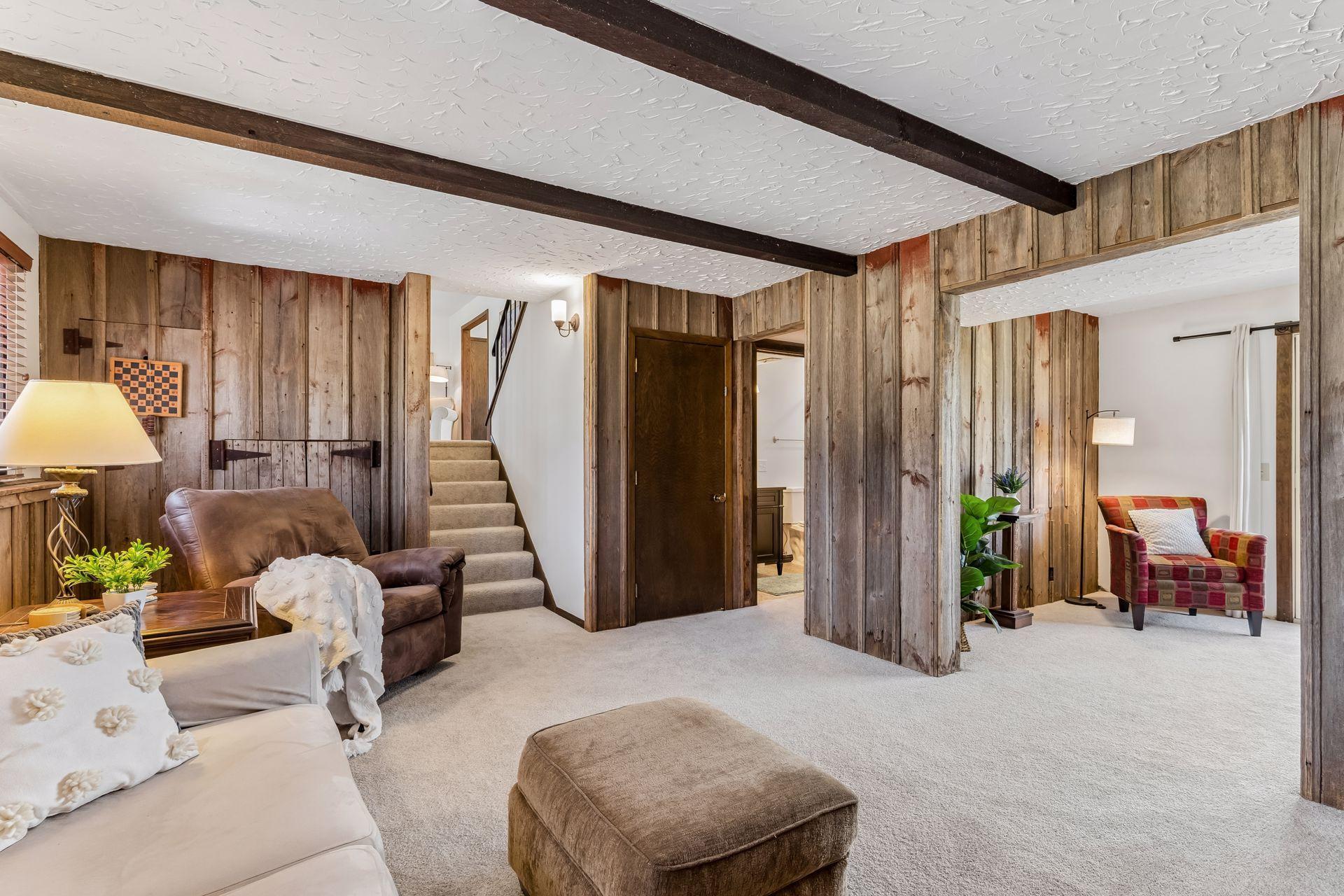 Expanded family room view highlighting cozy seating area, updated carpet and access to upper level.