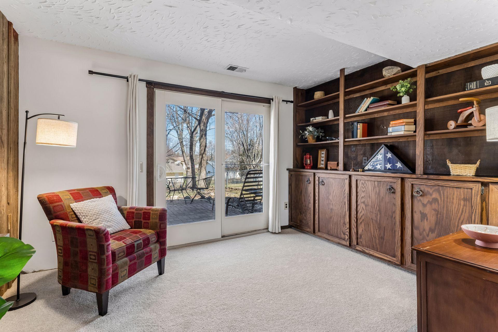 Walkout lower-level living area with glass patio door to backyard, offering potential for a fourth bedroom, guest suite or flexible living area (just add doors and a closet).