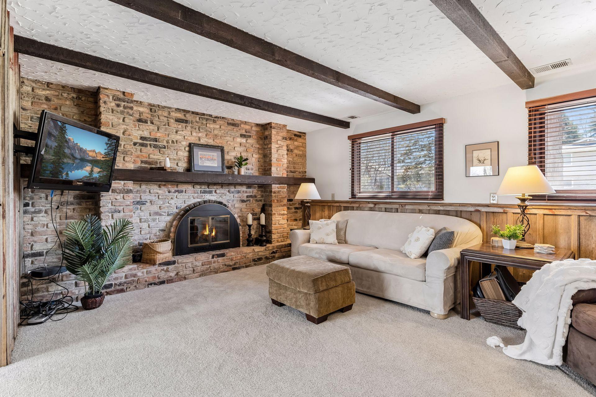 Additional family room view showcasing fireplace focal point, natural light from windows and spacious layout for entertaining.