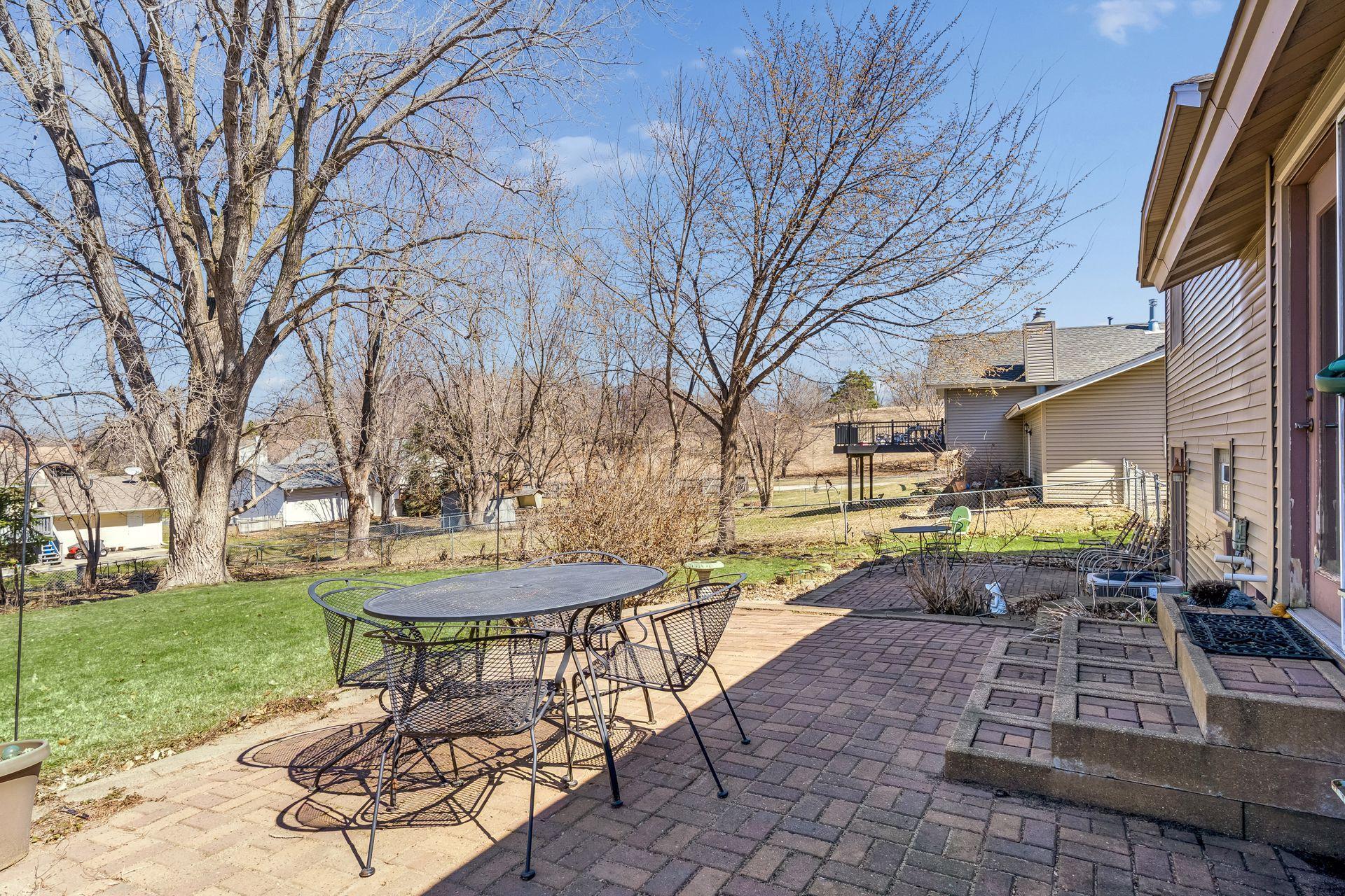 Backyard patio with paver design, ideal for outdoor dining, entertaining, and relaxing in a private setting.