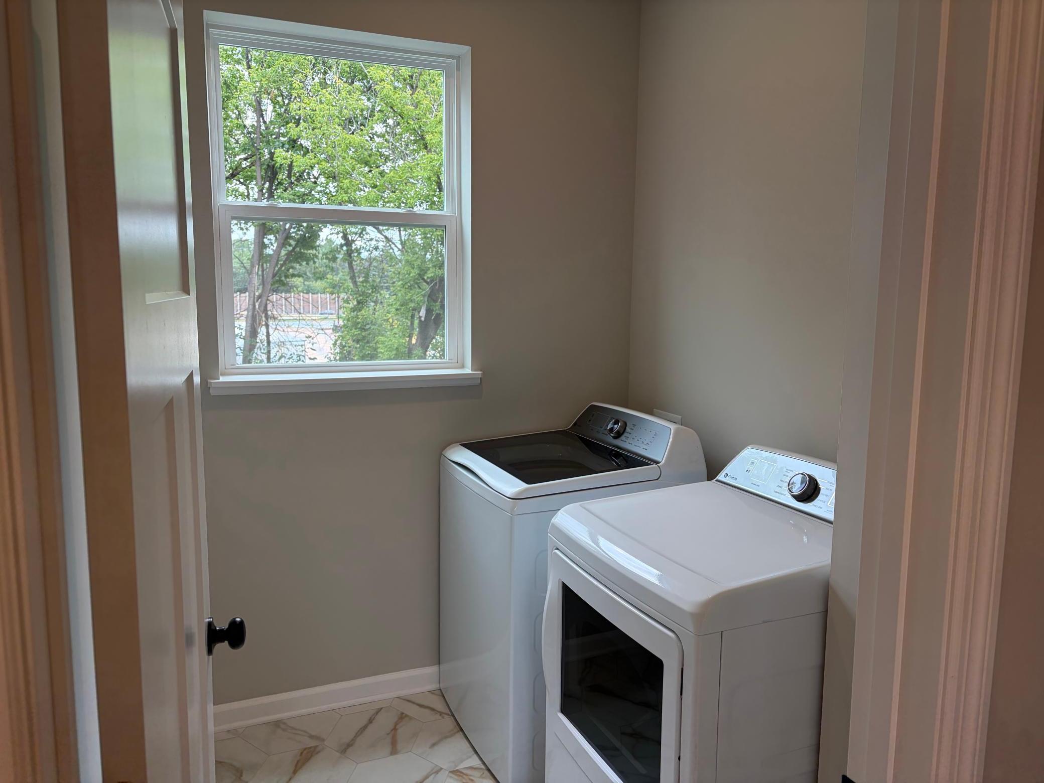 The laundry room features ample space with room above to add shelving.