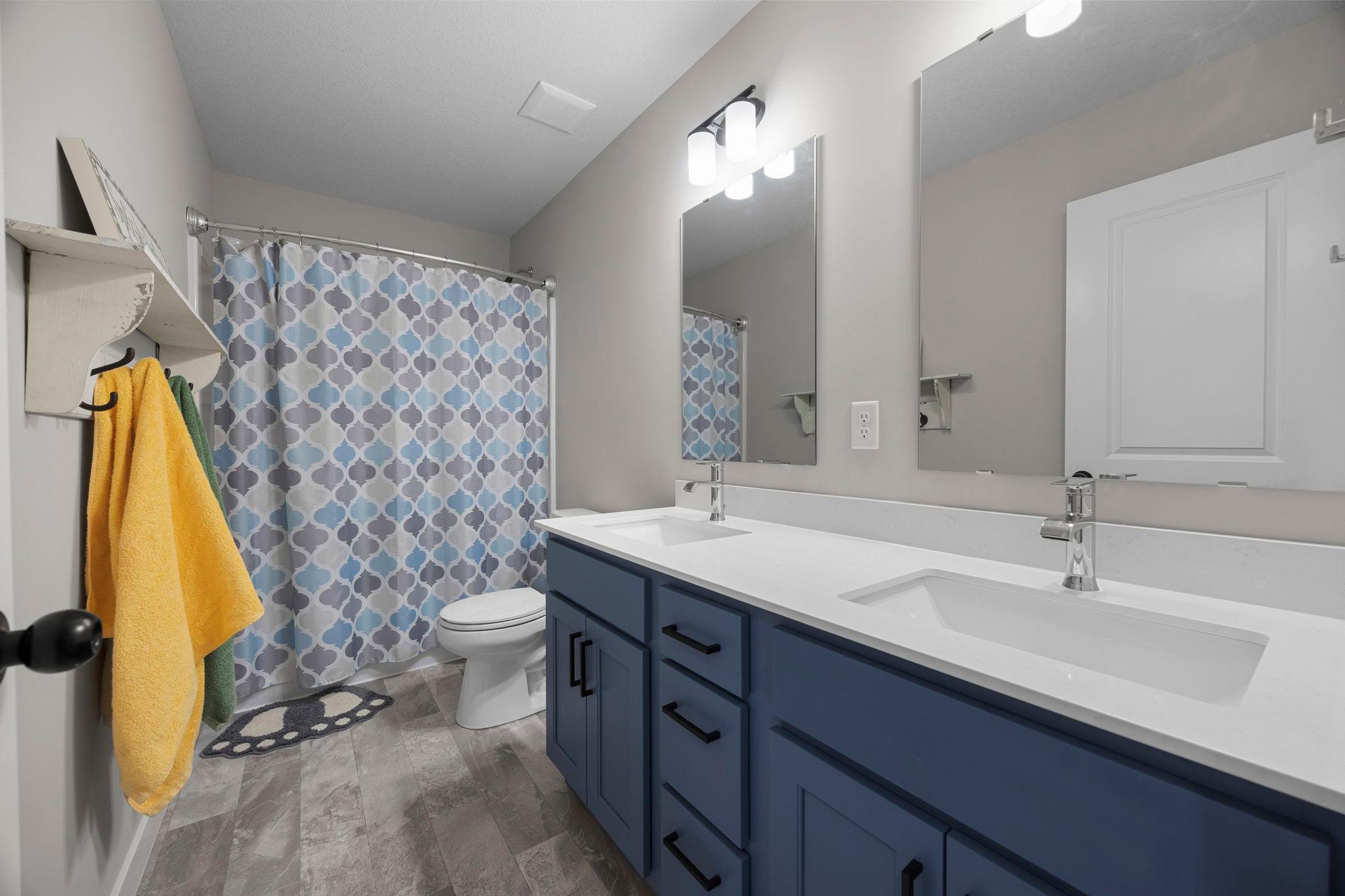 Upper level full bath with dual vanity.