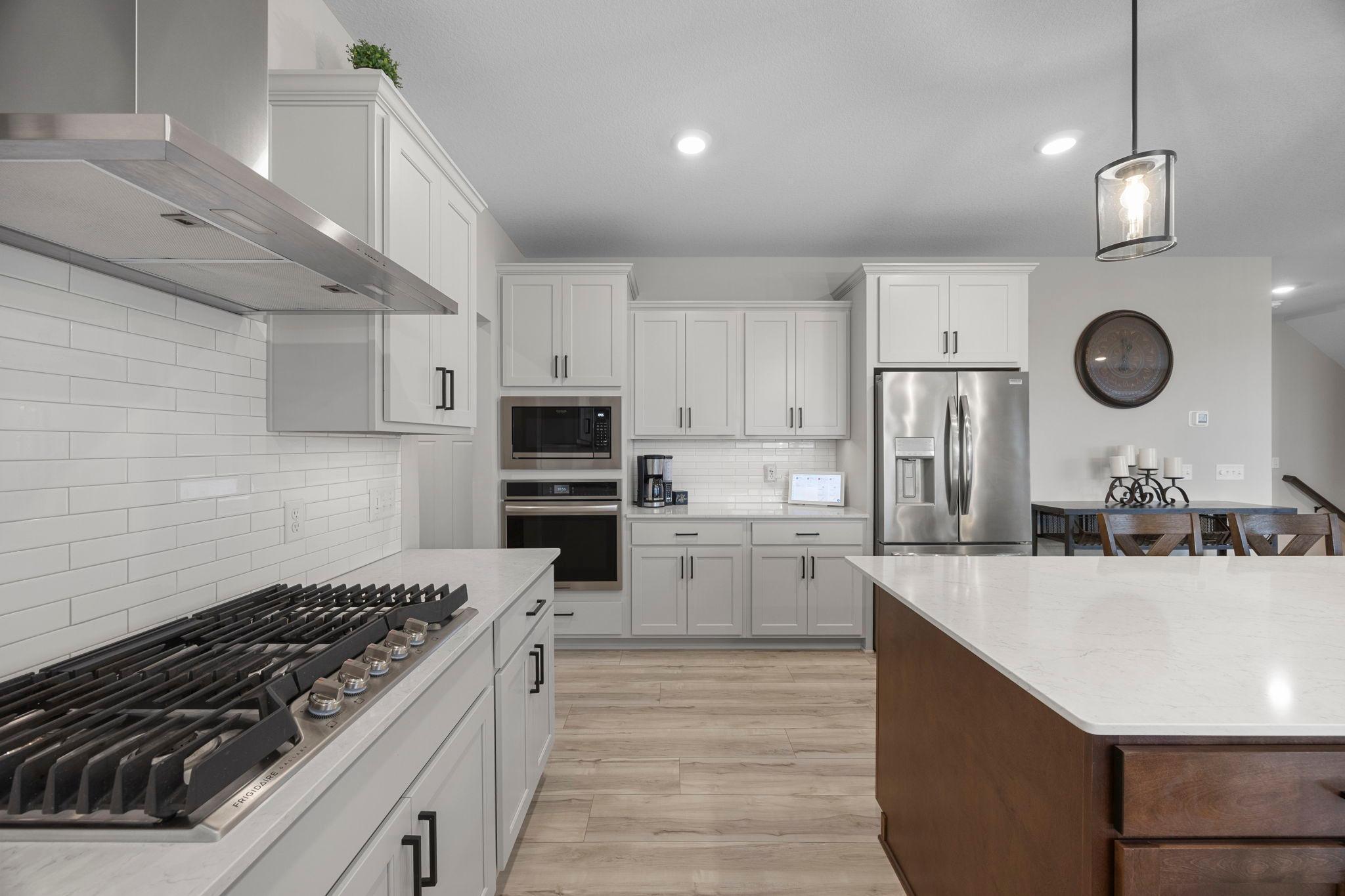 Stainless appliances include wall oven and microwave, cooktop and hood.