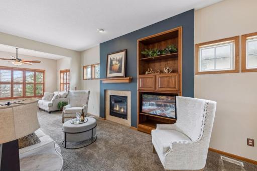 Cozy fireplace in main level living room with nice built-in and transom windows allowing abundant natural light without compromising privacy.