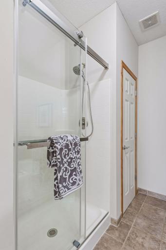 Walk-in shower with newer frameless door.