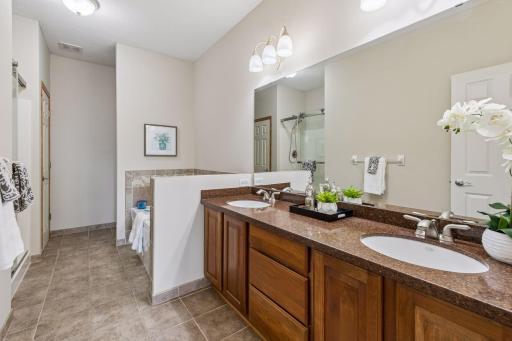Owner's private bath features dual sink vanity, separate tub and shower and neutral decor.